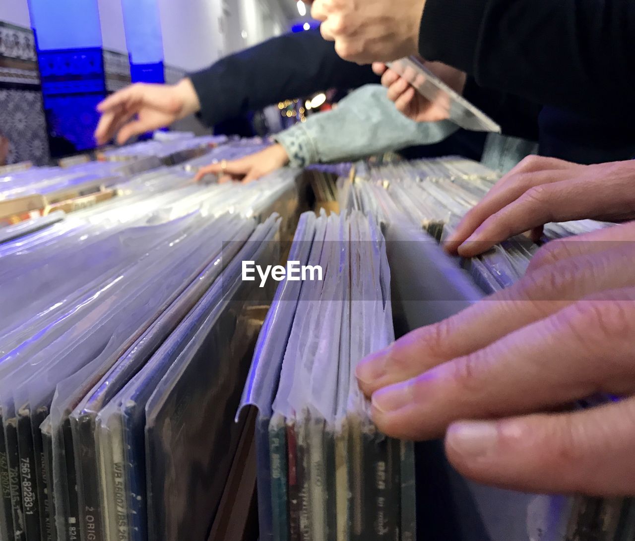 Midsection of people looking at vinyl records