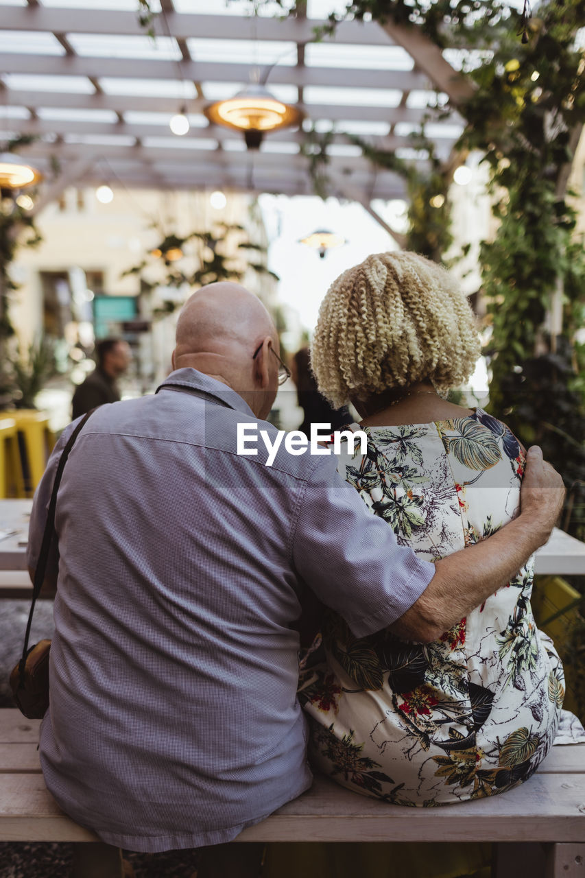 Rear view of senior man and woman sitting in cafe during weekend