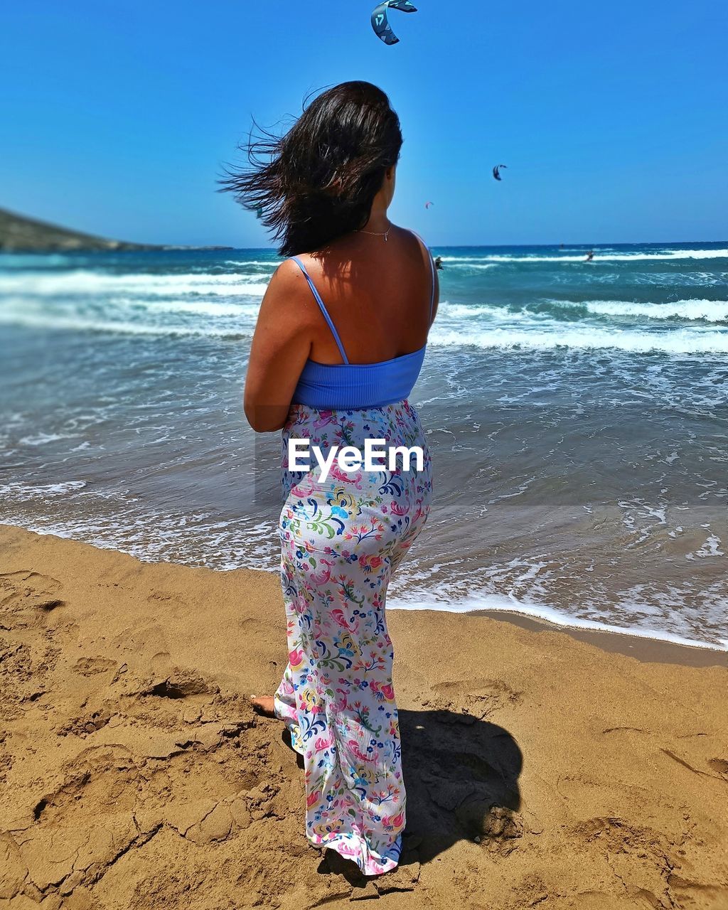 beach, land, water, sea, one person, sand, nature, sky, rear view, women, vacation, full length, holiday, trip, motion, leisure activity, child, childhood, standing, body of water, female, clothing, wave, ocean, horizon over water, day, hairstyle, horizon, blue, beauty in nature, adult, shore, sunlight, lifestyles, outdoors, summer, sunny, person, casual clothing, clear sky, scenics - nature, travel destinations, photo shoot, tranquility, dress