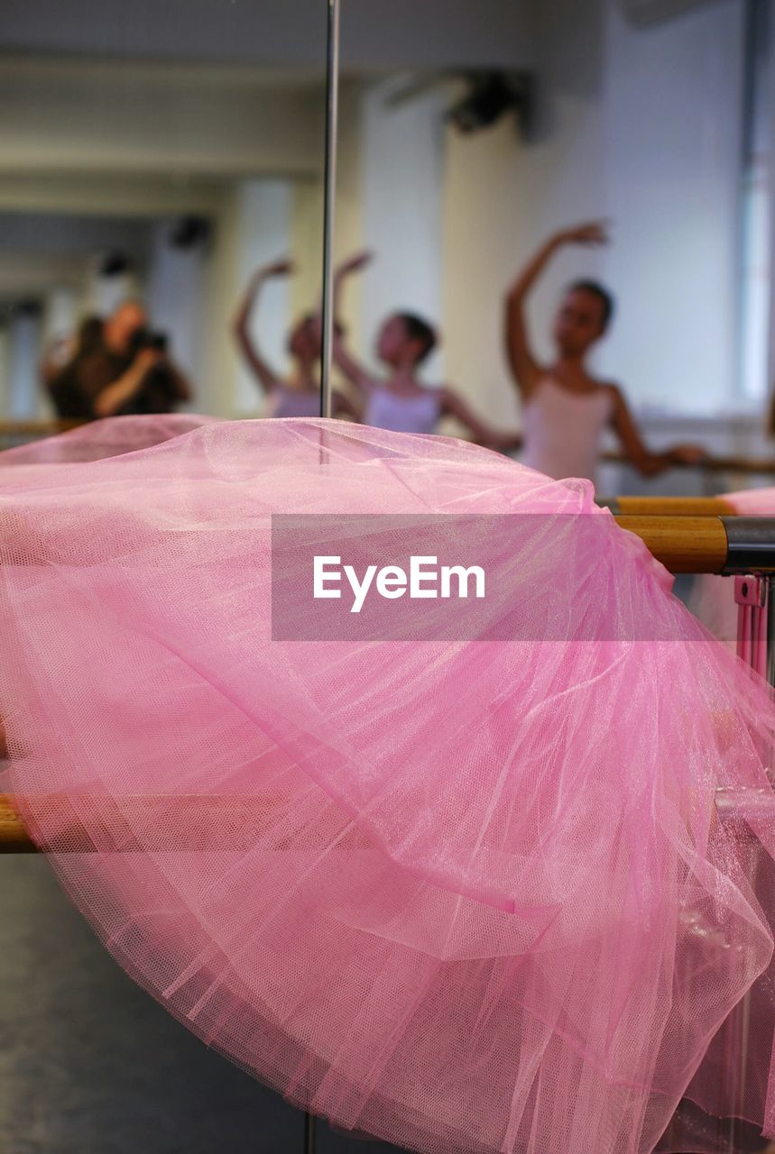 Close-up of pink tutu with ballerinas at studio