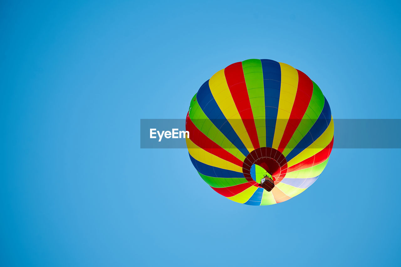 Low angle view of hot air balloon against clear blue sky