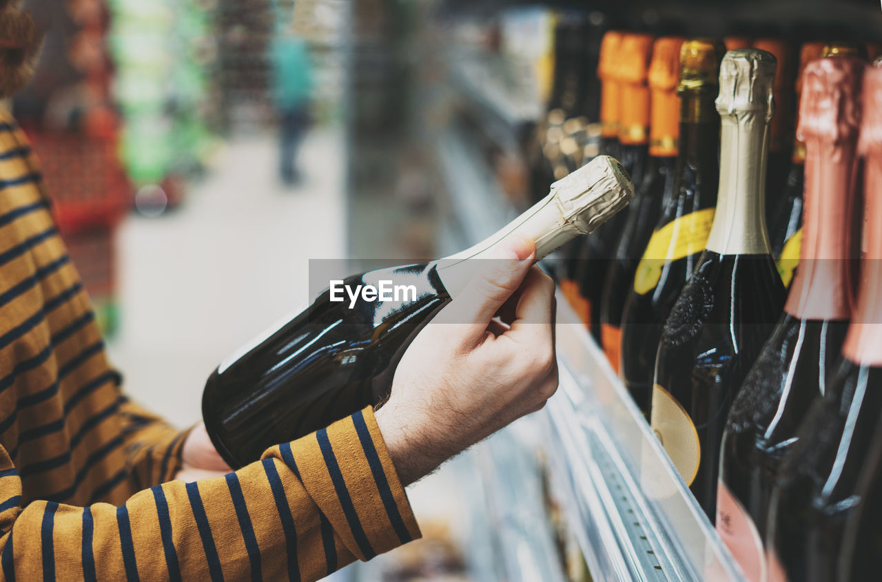 Man chooses wine at supermarket