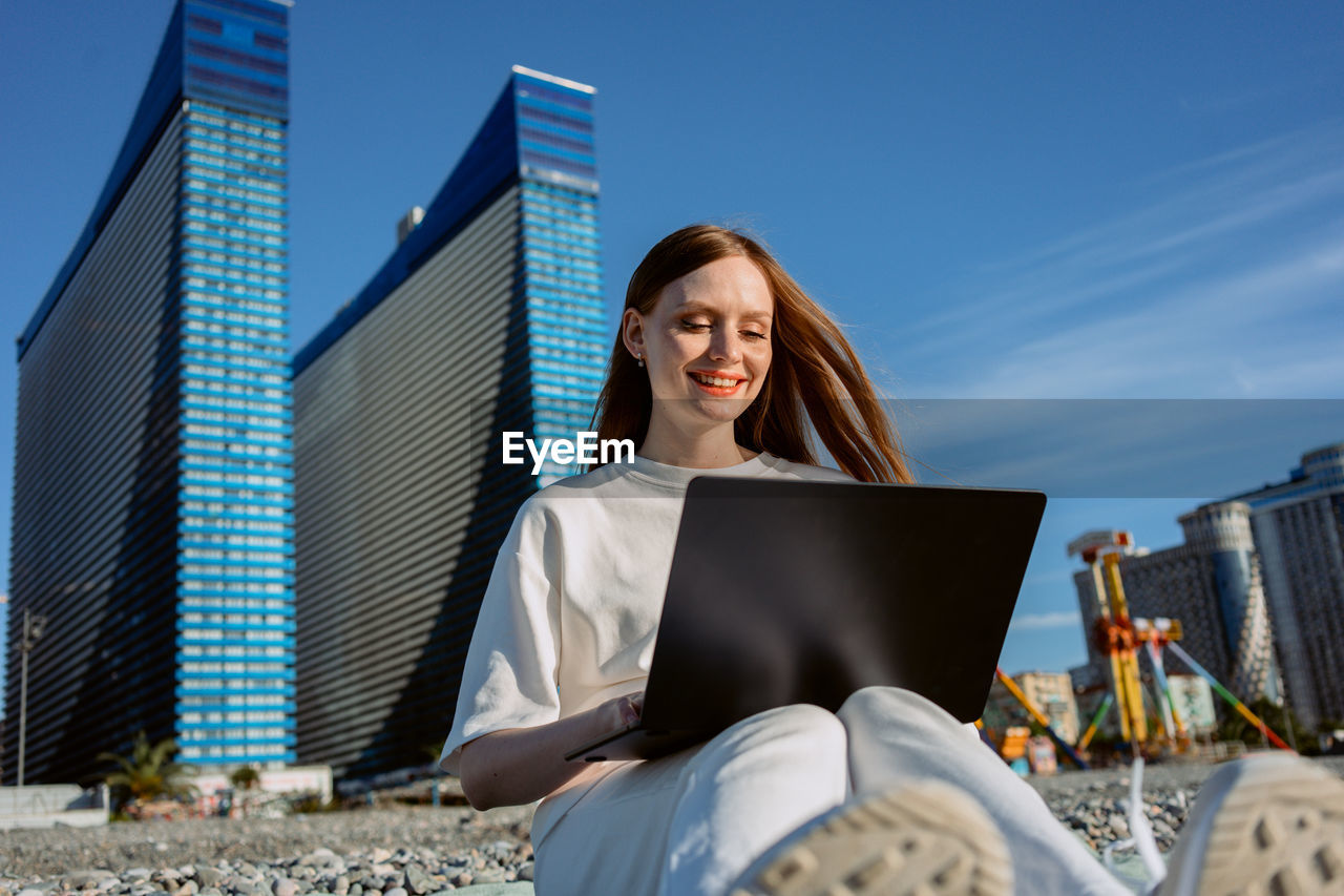 A girl with a laptop works on the beach. freelance programmer. realtor. high quality photo