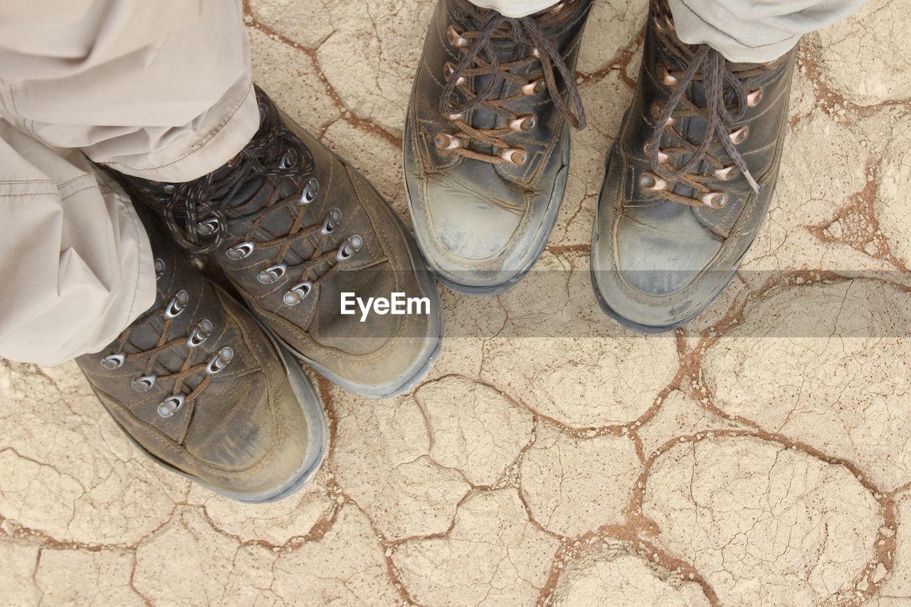 Low section of men standing on cracked field