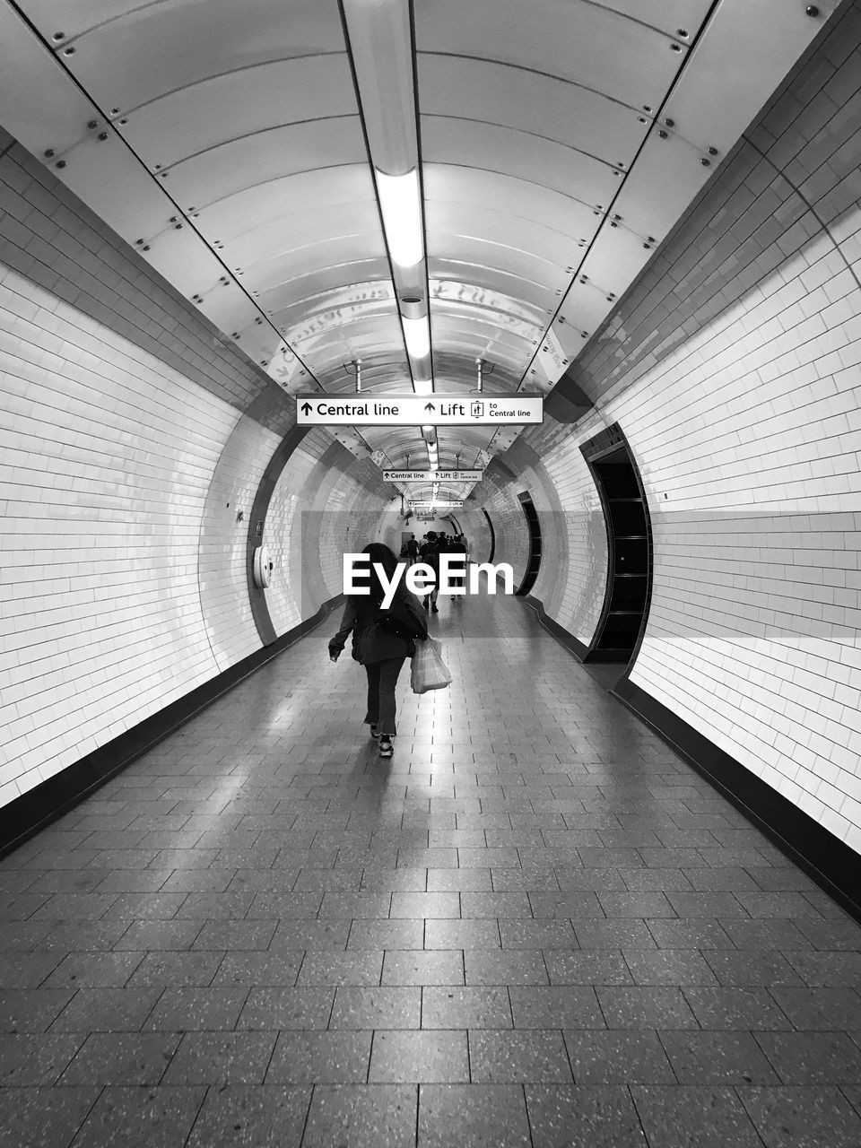 FULL LENGTH REAR VIEW OF MAN WALKING IN SUBWAY