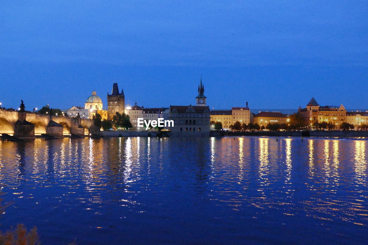 REFLECTION OF ILLUMINATED BUILDINGS IN WATER AT NIGHT