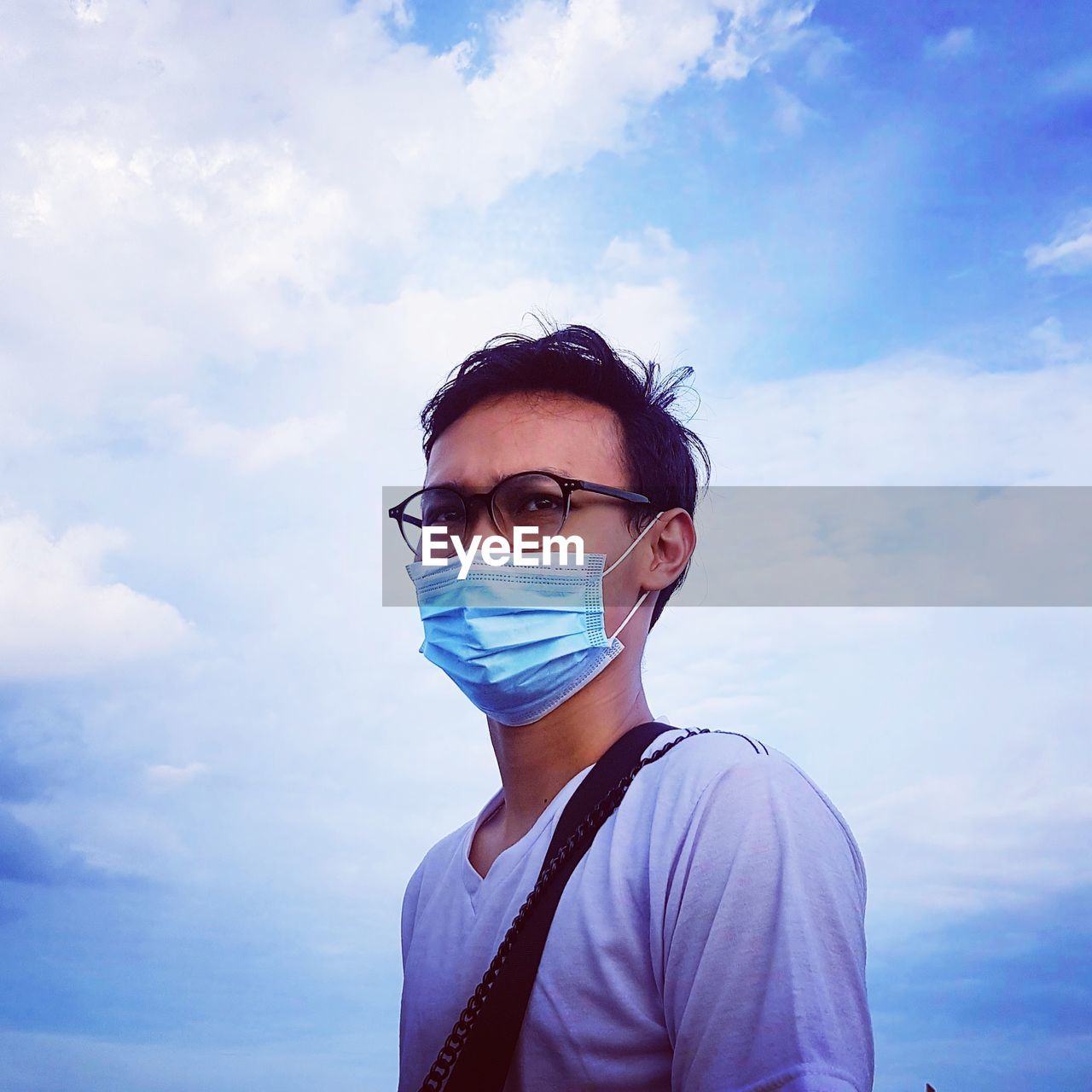 Portrait of young man standing against sky