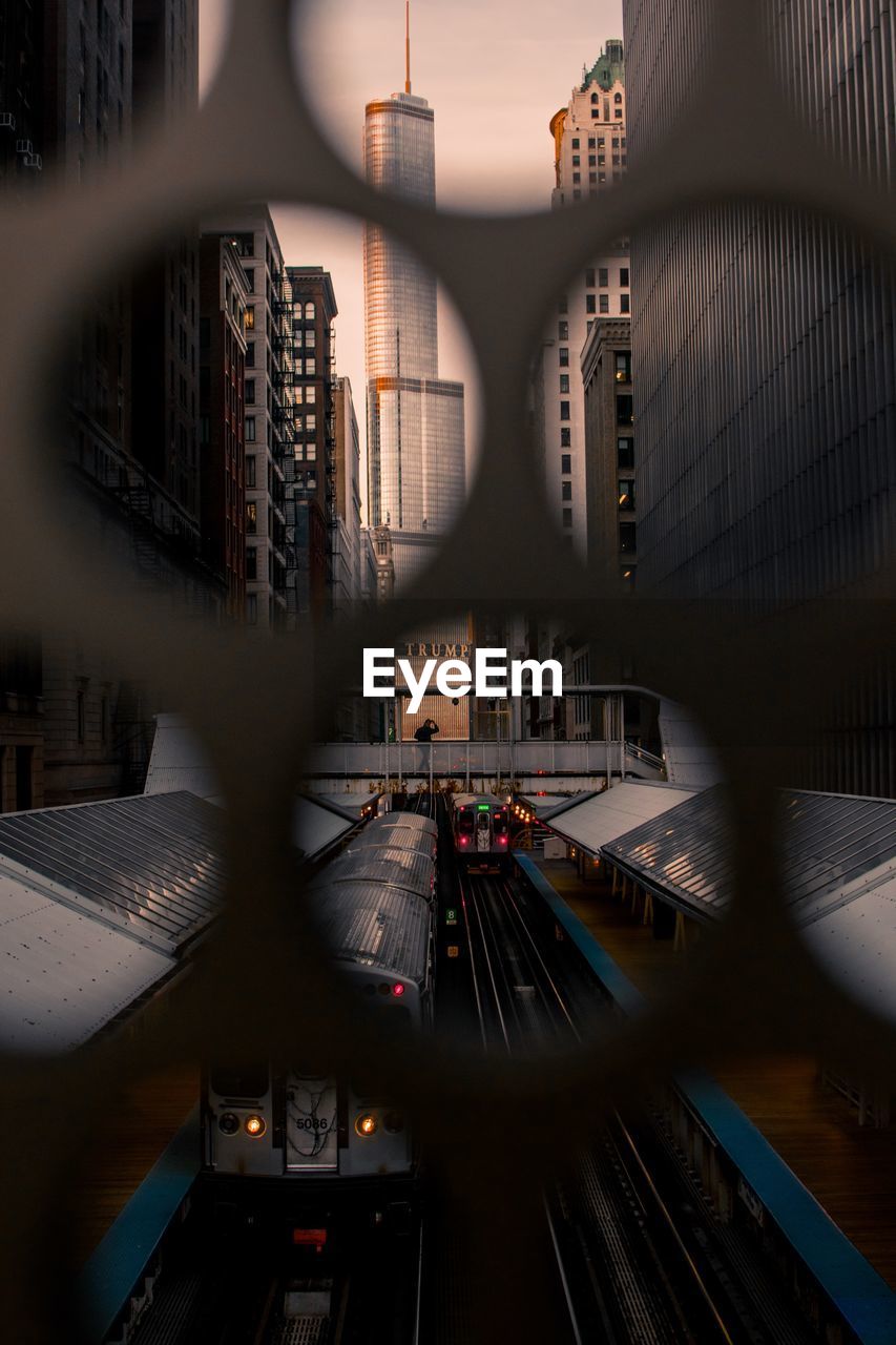 Railroad station seen through metal grate in city