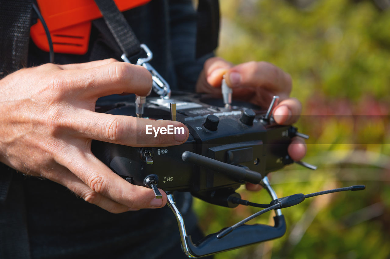Close-up of a man's hands holding a transmitter and control equipment for an fpv drone quadcopter