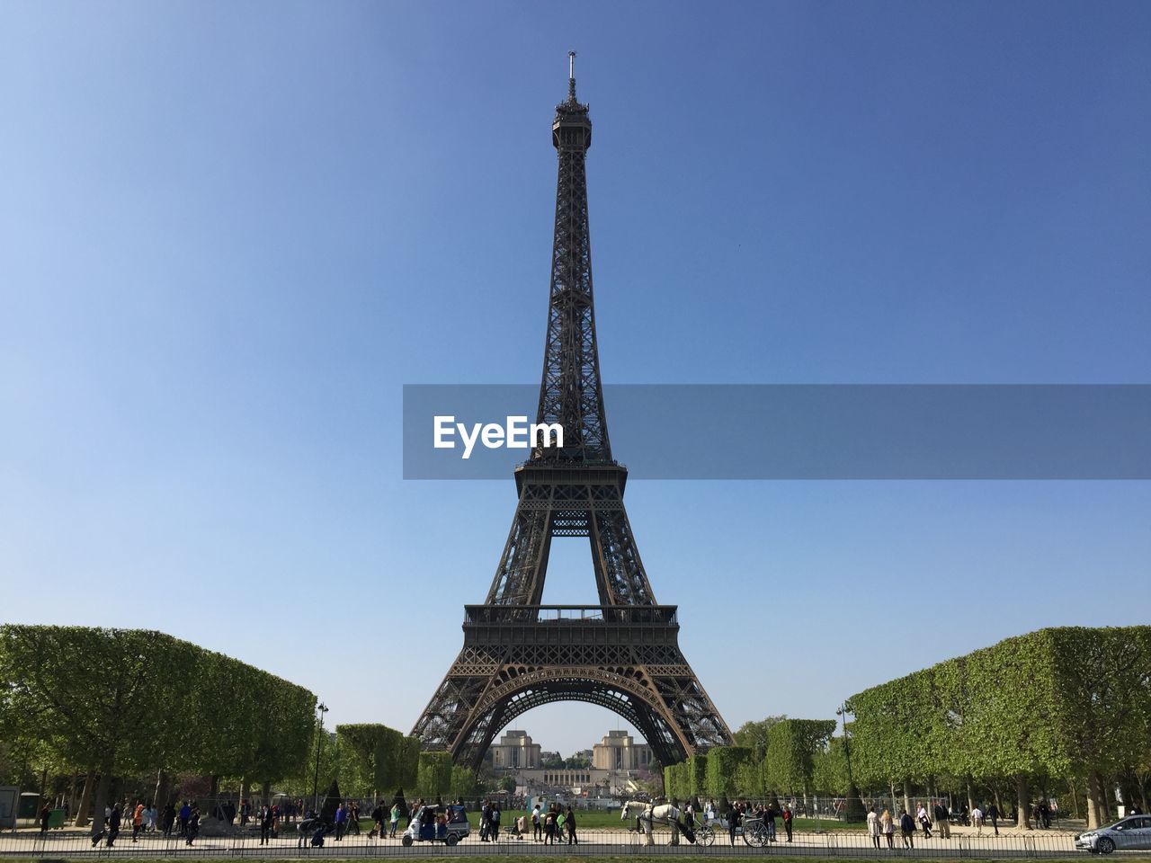 Group of people in city against sky, eiffel tower