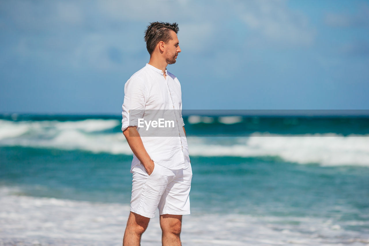 full length of young man standing at beach