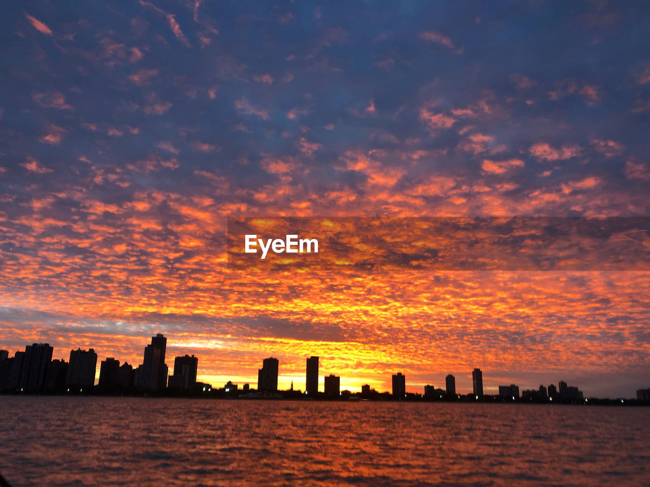 SCENIC VIEW OF SEA AND BUILDINGS AGAINST SKY DURING SUNSET