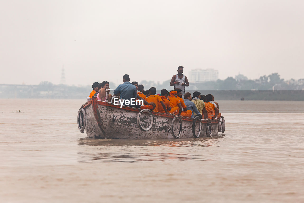 PEOPLE ON BOAT AGAINST SEA