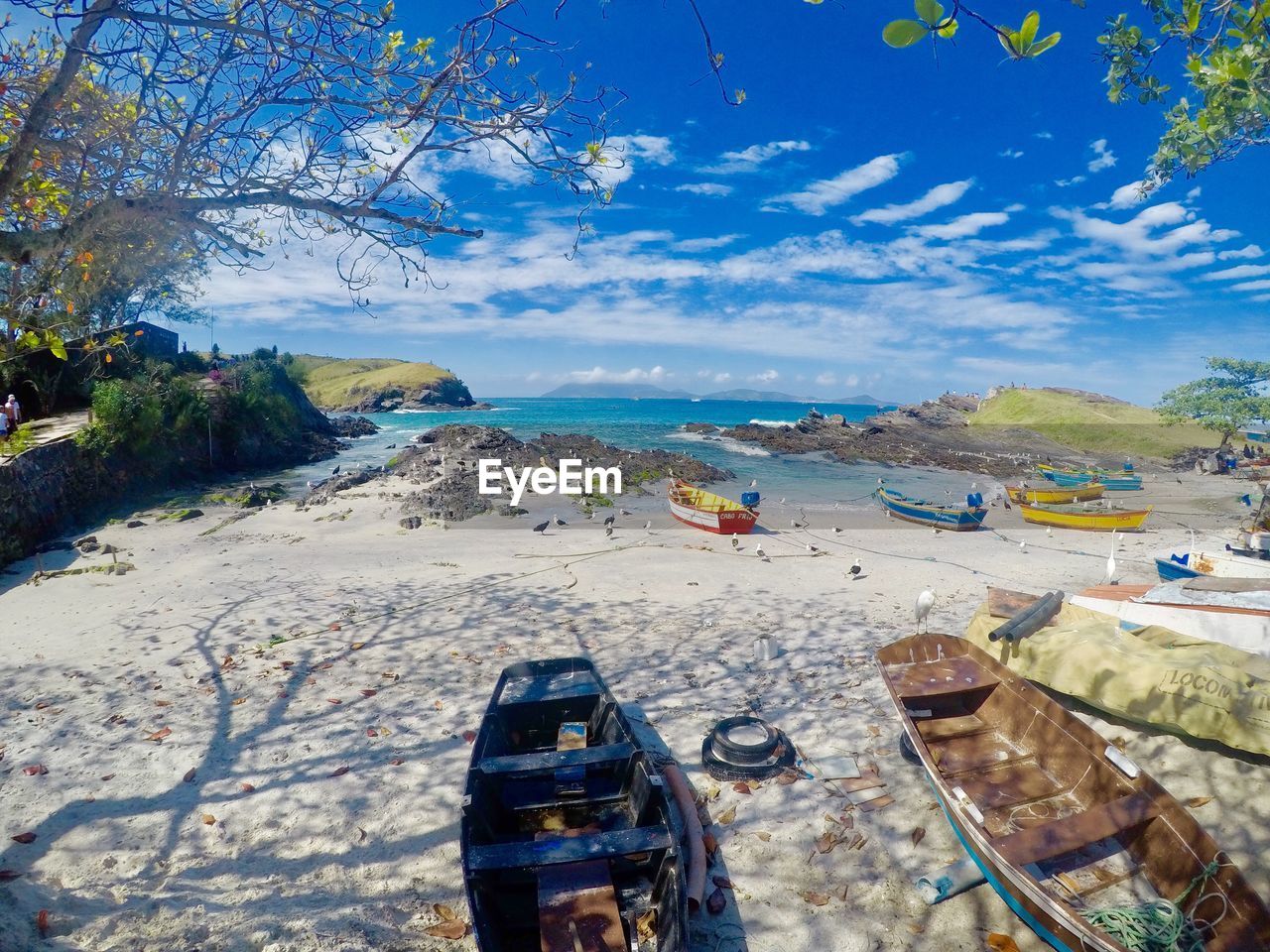 BOATS MOORED ON SHORE AGAINST SKY