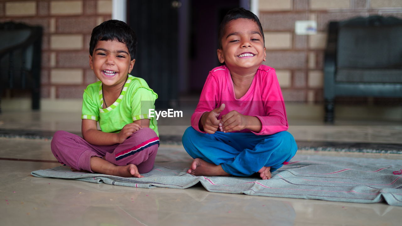 Indian little boy is smiling while doing yoga in hall at home. worldwide yoga day concept.