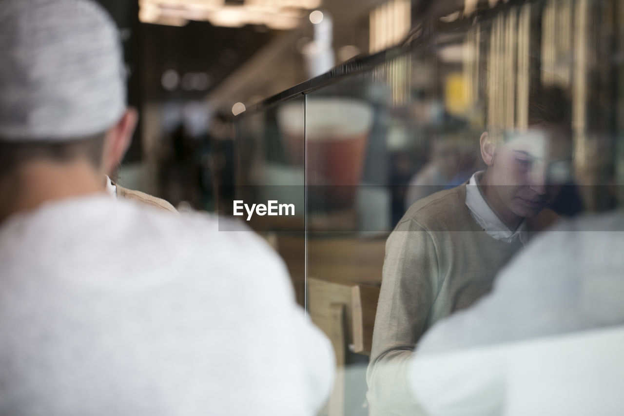 Rear view of man with woman sitting in cafe