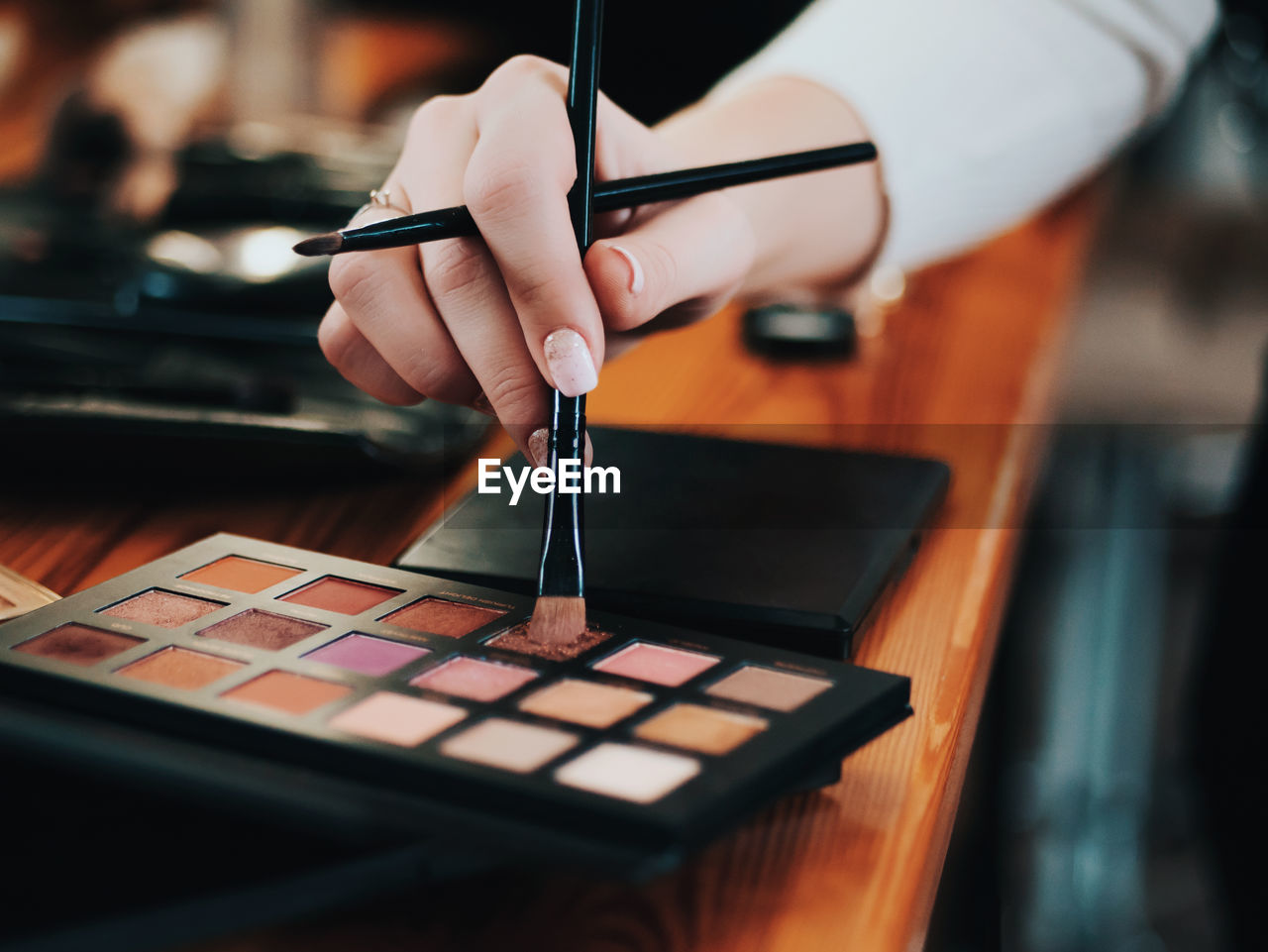 Cropped hand of woman applying make-up