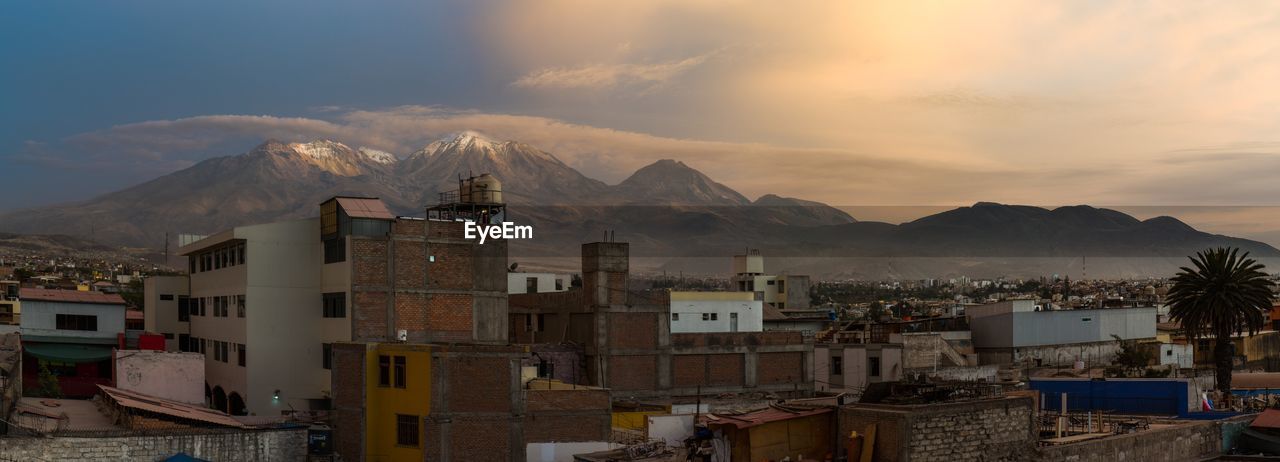 TOWNSCAPE BY MOUNTAINS AGAINST SKY