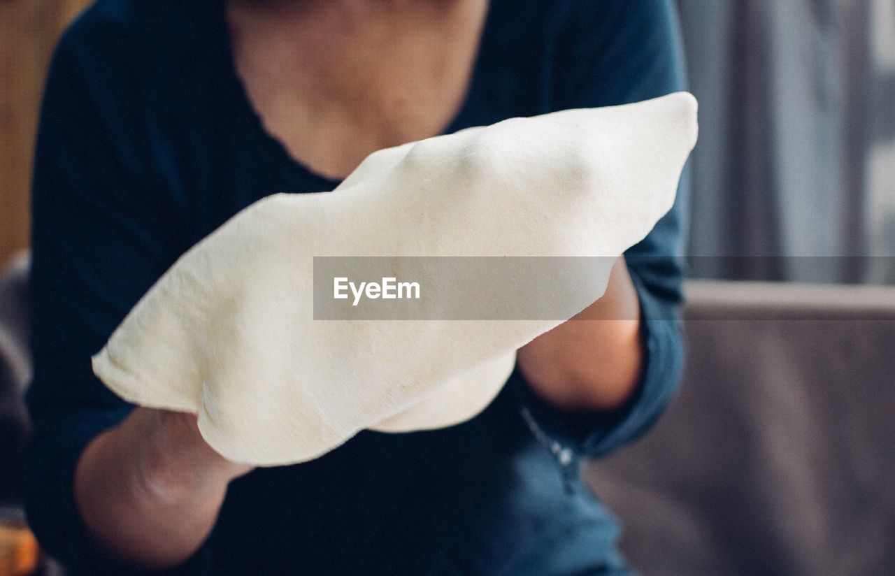 Midsection of woman holding rolled dough