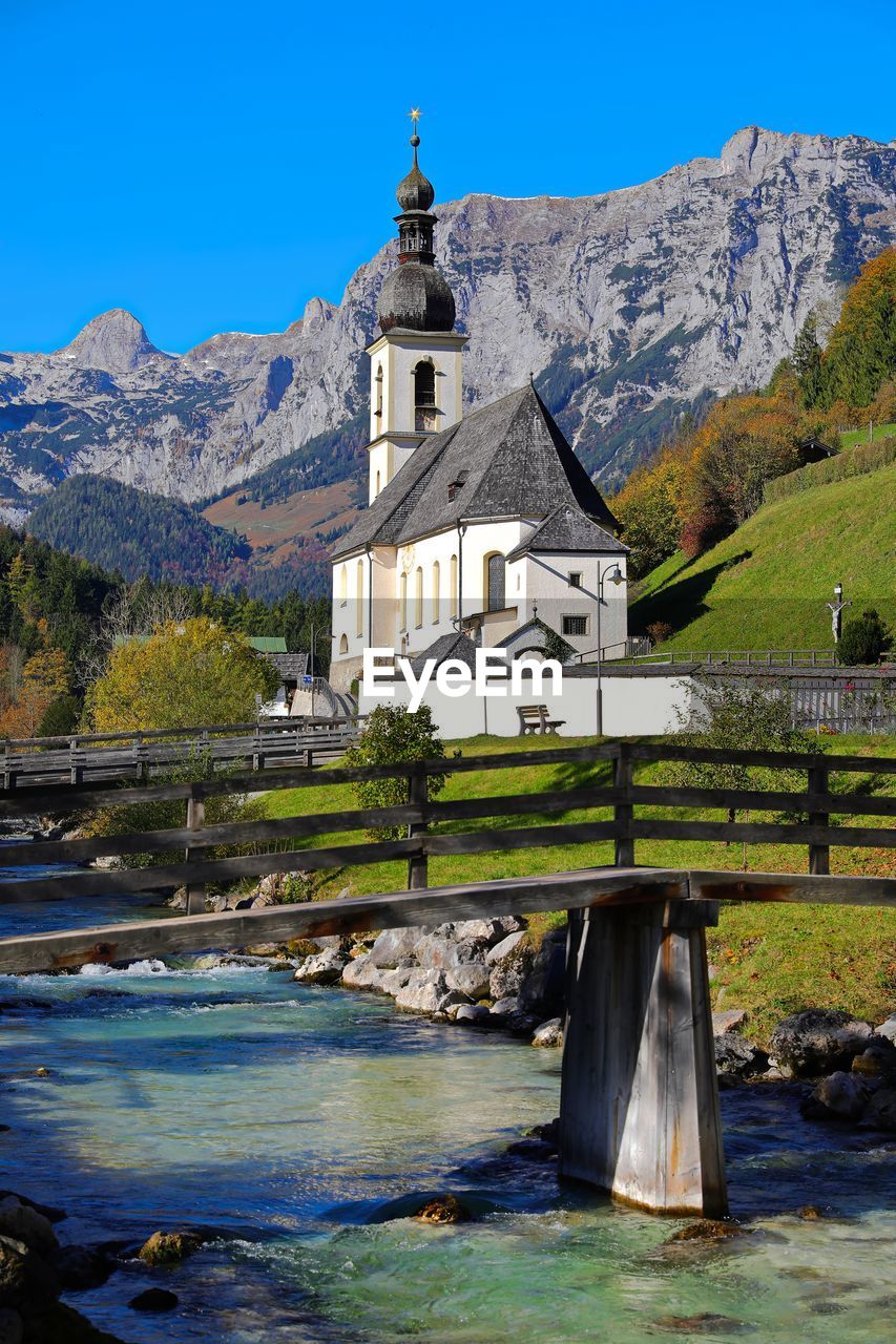 VIEW OF BUILDING BY MOUNTAINS AGAINST SKY