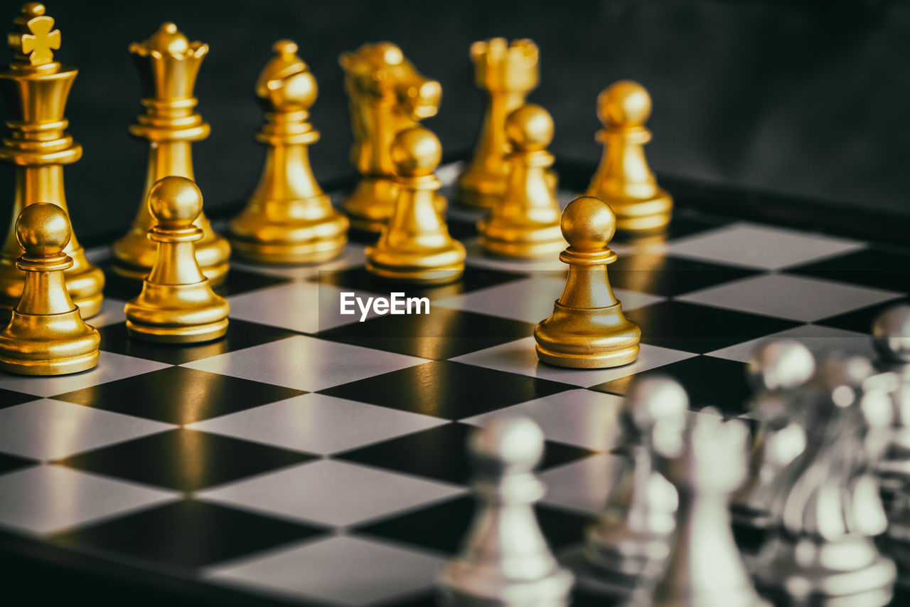 Close-up of golden and silver chess pieces on board