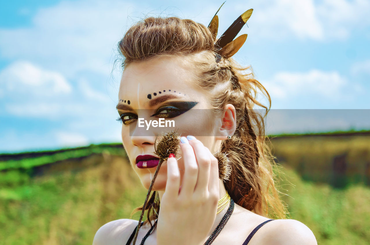 PORTRAIT OF YOUNG WOMAN AGAINST SKY IN BACKGROUND