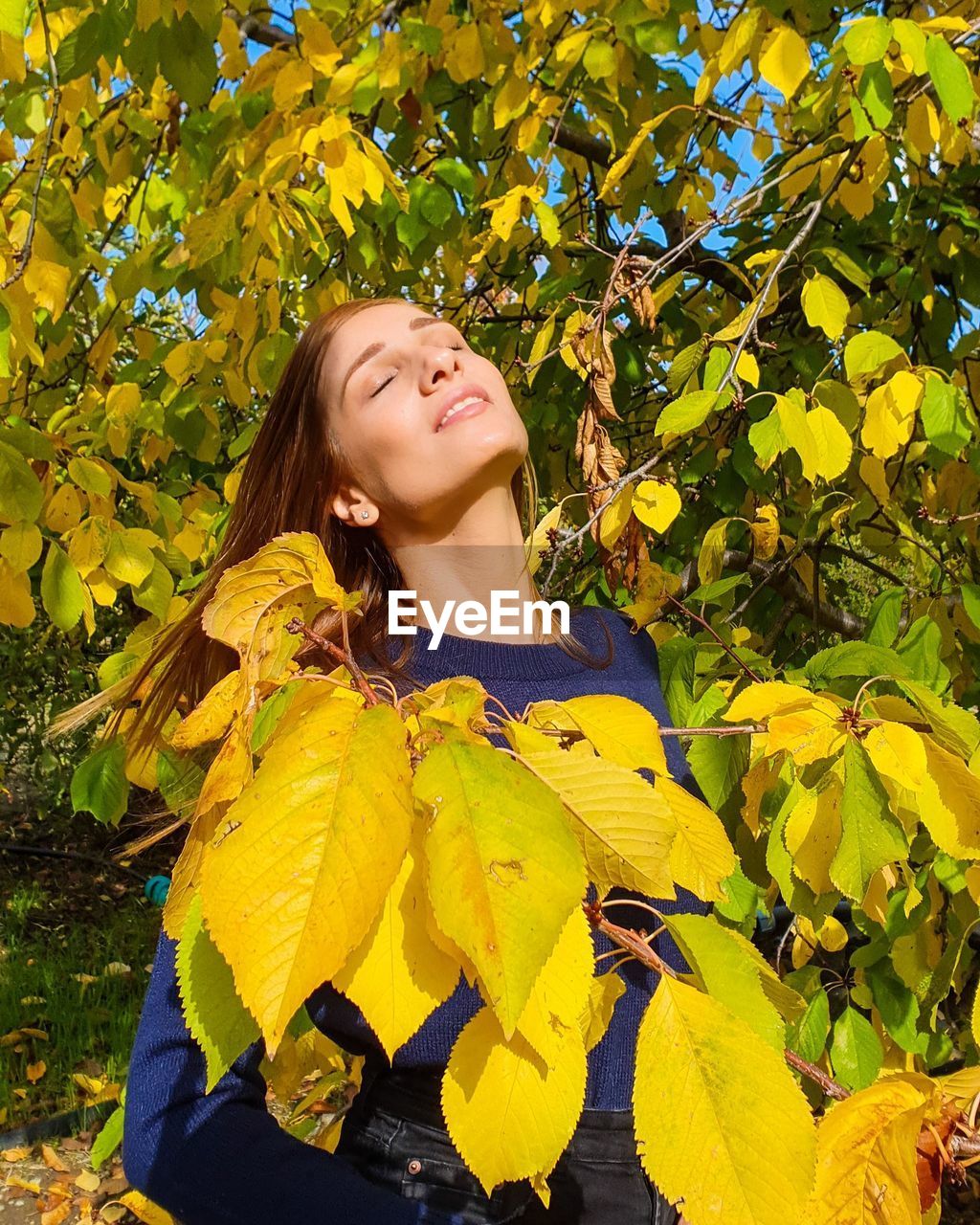 Portrait of smiling woman standing against yellow plants