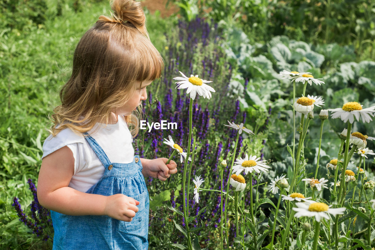 CLOSE-UP OF GIRL STANDING ON FIELD