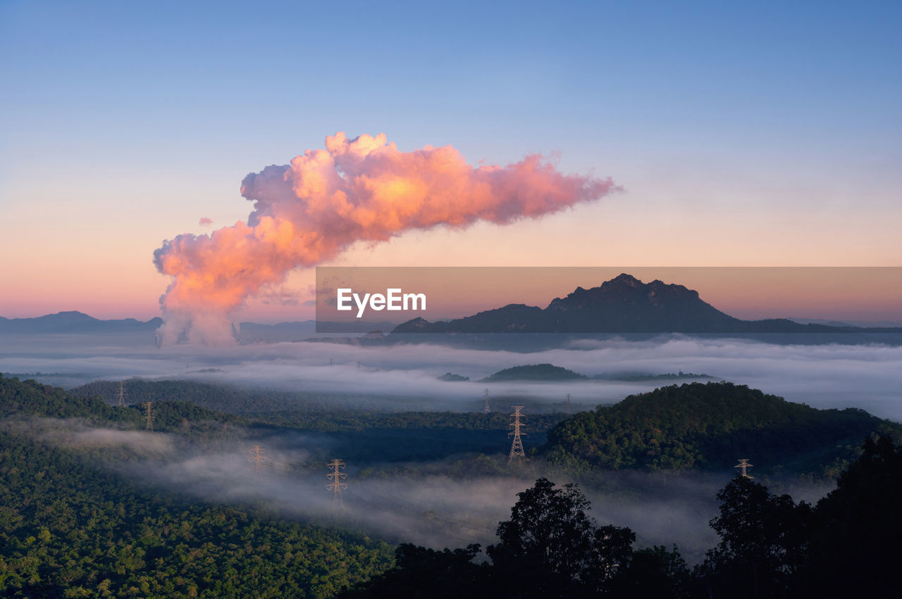 Fog in the forest, high voltage pole and steam from coal power plant. mae moh, lampang, thailand. 