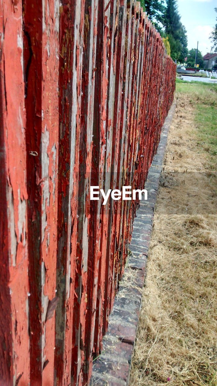 Red wooden fence on field