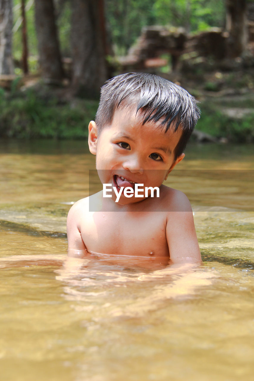 Portrait of cute boy in water