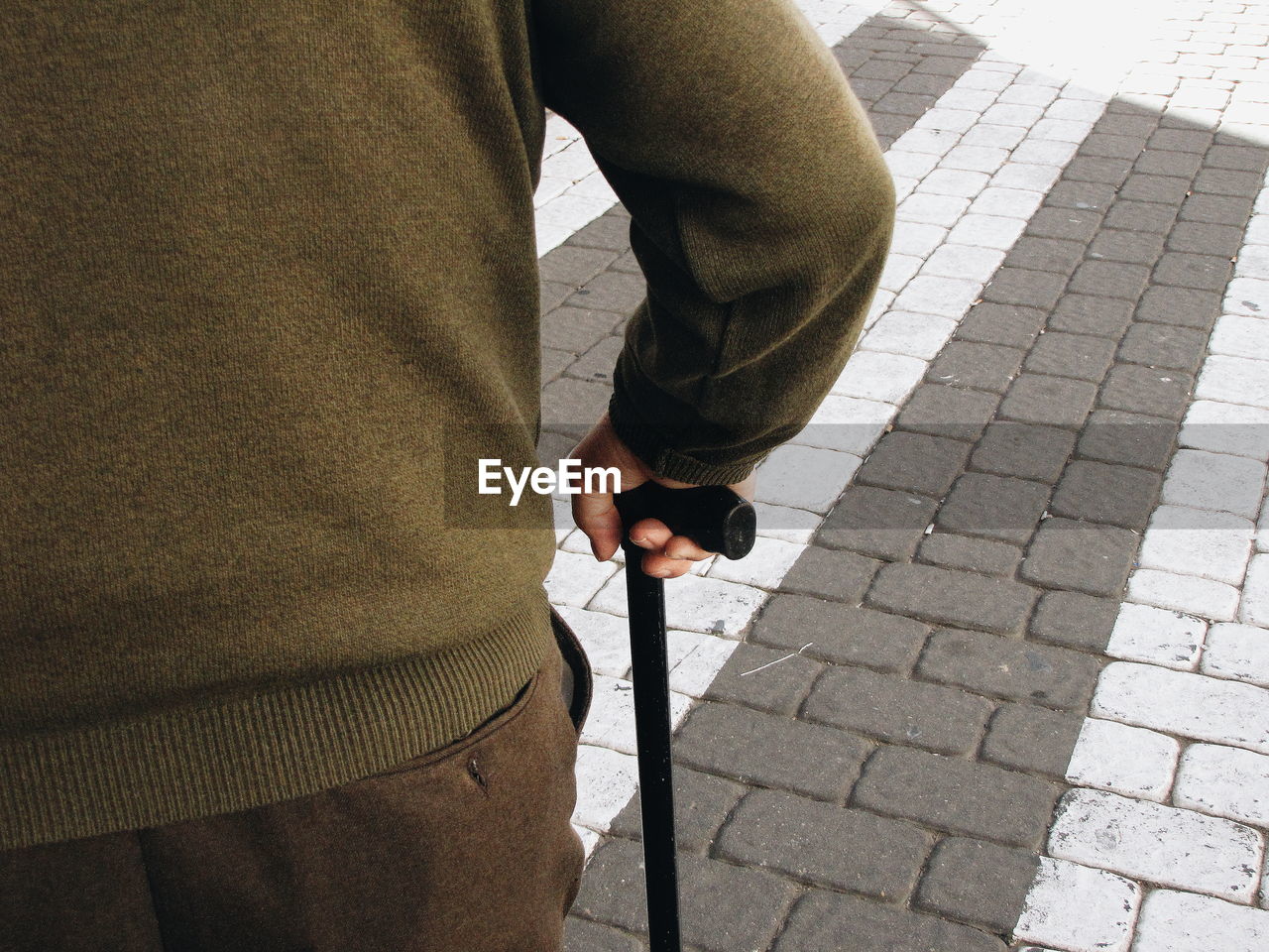 Rear view of man standing with walking cane on street