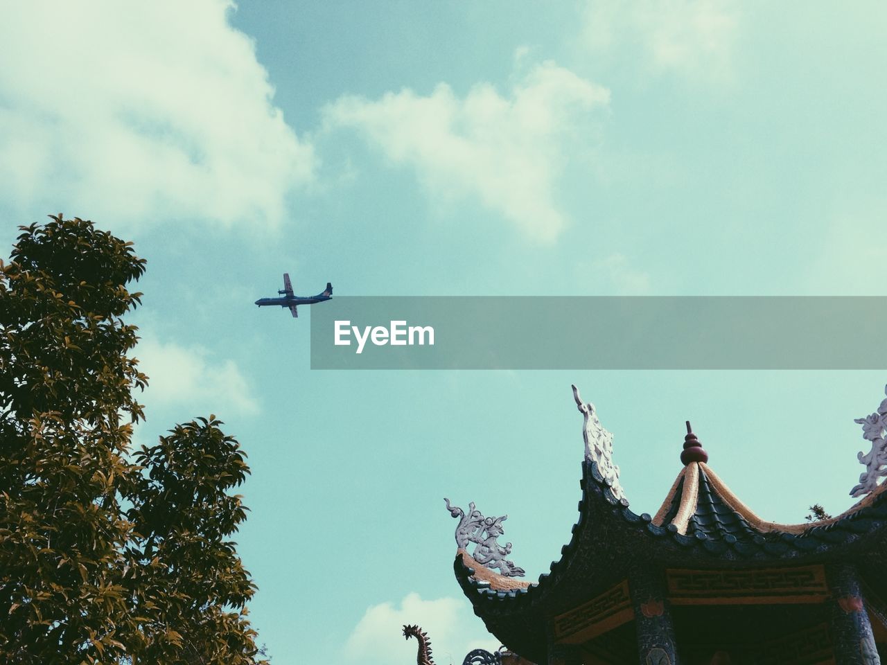 Low angle view of airplane flying over building