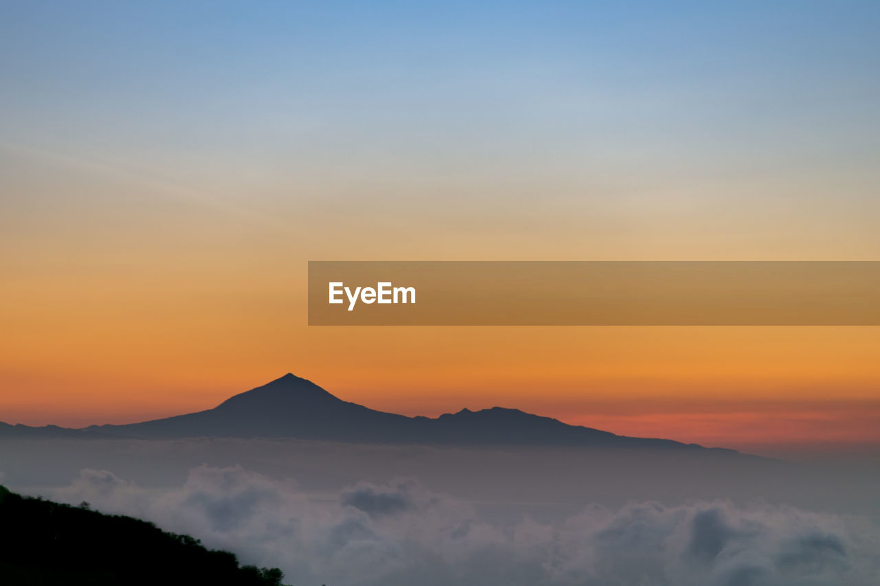 Scenic view of silhouette mountains against sky during sunset