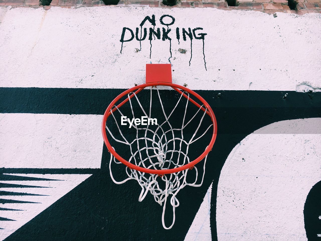 Low angle view of basketball hoop with text on wall