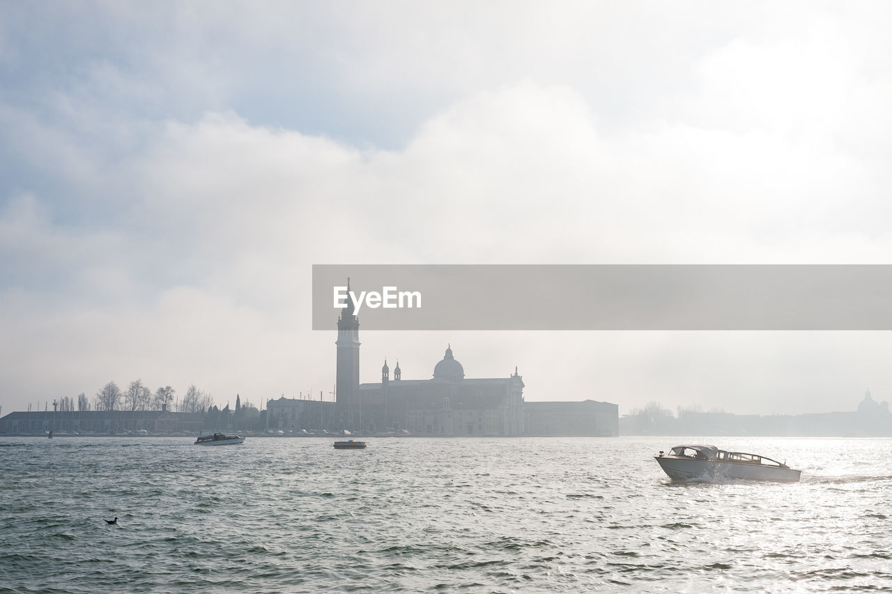 Boat moving on grand canal by san giorgio maggiore against sky