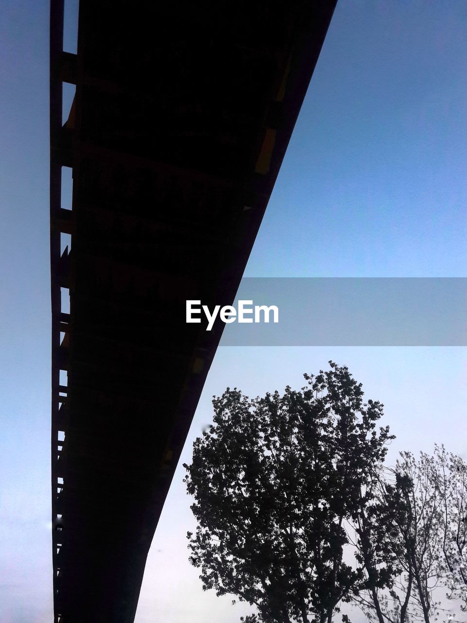 LOW ANGLE VIEW OF BRIDGE AGAINST SKY AT DUSK