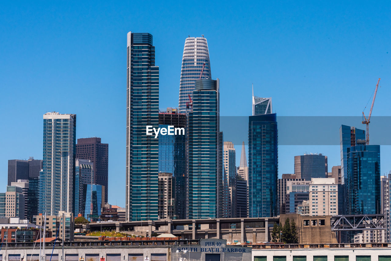 Skyscrapers in city against clear blue sky