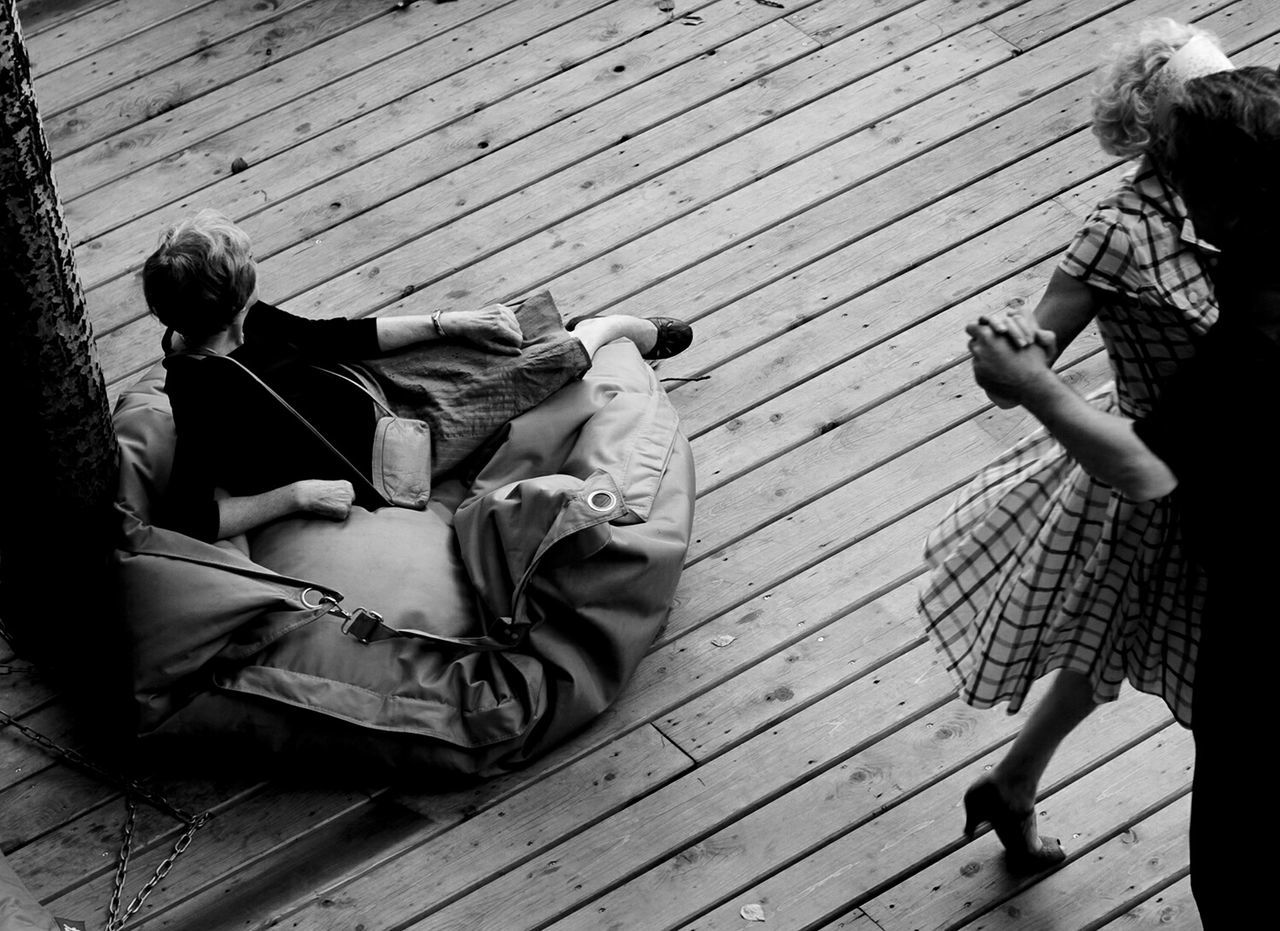 High angle view of friends dancing while man relaxing on bean bag