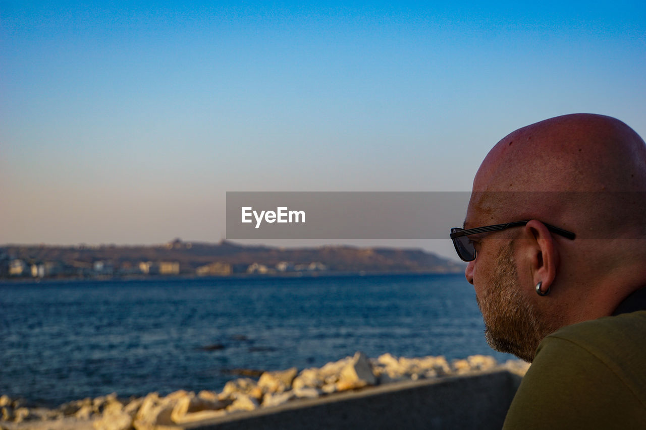 Portrait of man wearing sunglasses against clear sky