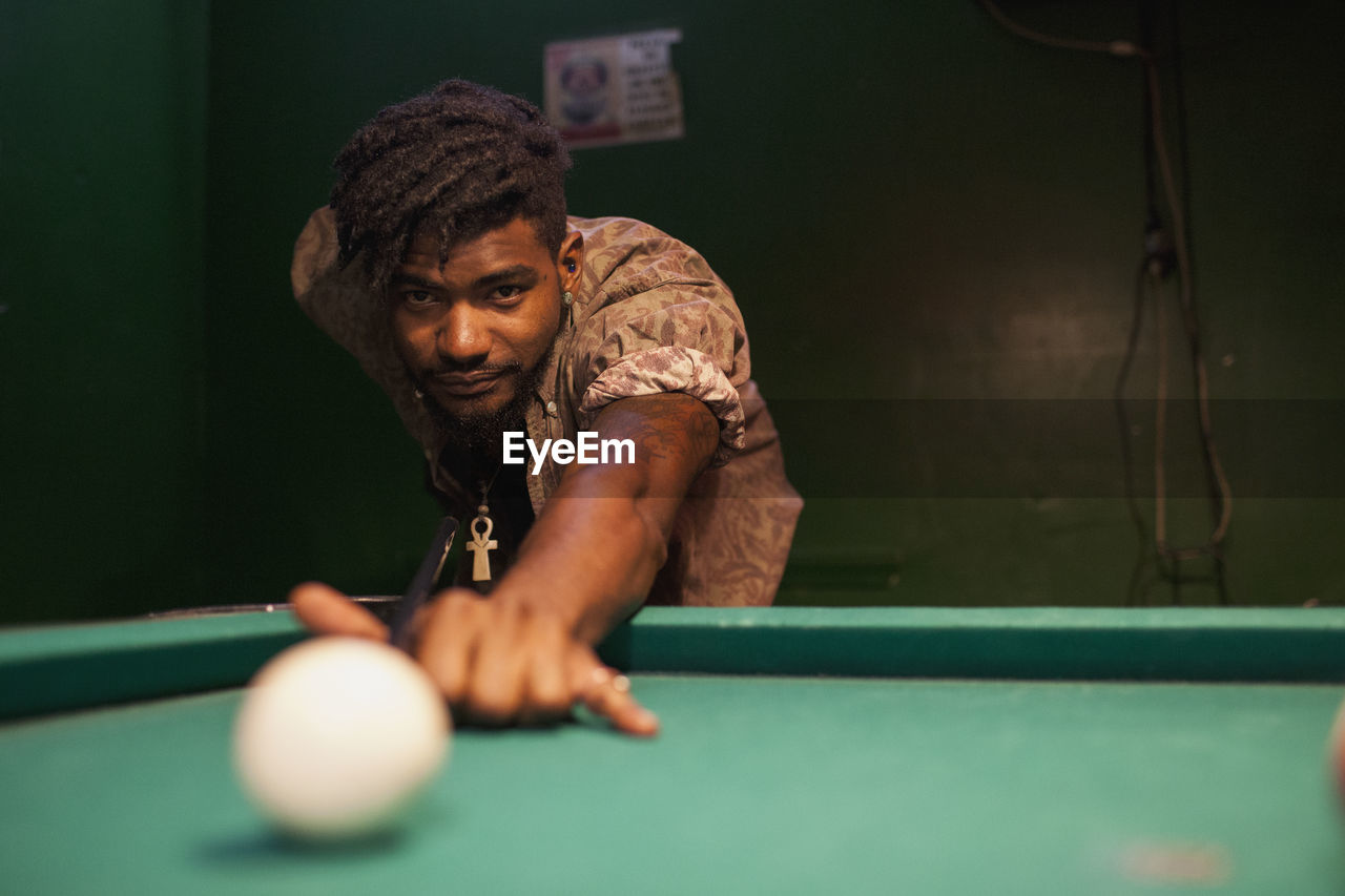 A young man playing pool.