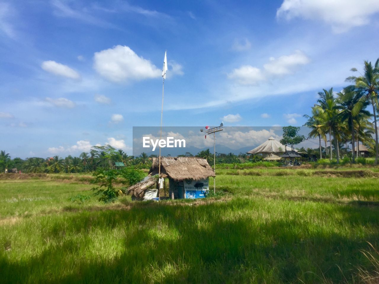 Scenic view of grassy field against cloudy sky