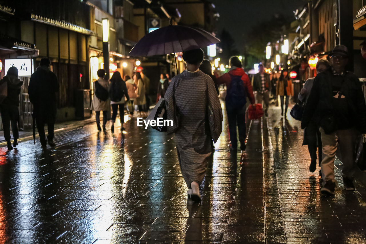 PEOPLE ON WET STREET IN RAINY SEASON