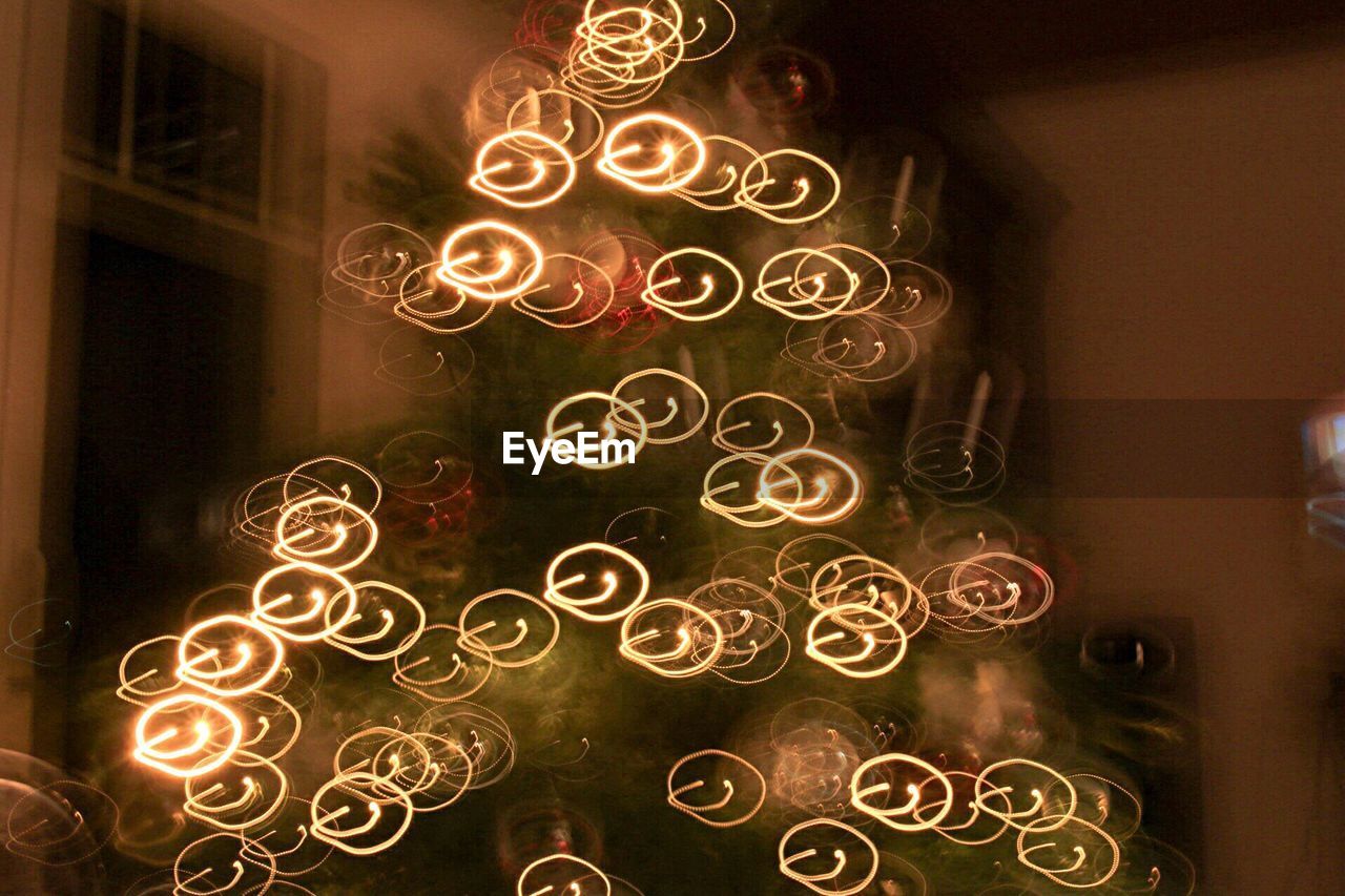 Defocused image of illuminated christmas tree at home