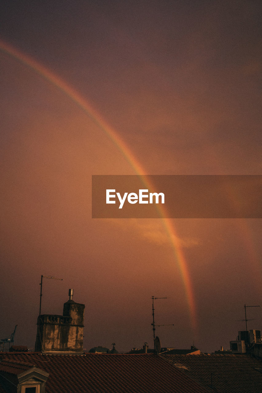 rainbow, sky, beauty in nature, architecture, cloud, nature, built structure, dusk, building exterior, sunset, scenics - nature, no people, multi colored, evening, city, dramatic sky, environment, tranquility, outdoors, building, night, idyllic, double rainbow, storm, orange color