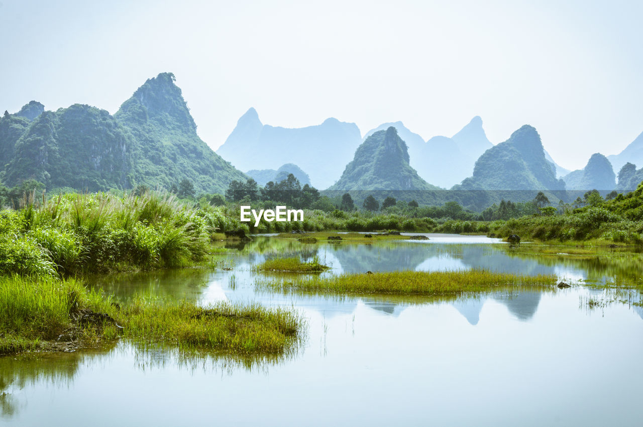 Scenic view of lake and mountains against sky