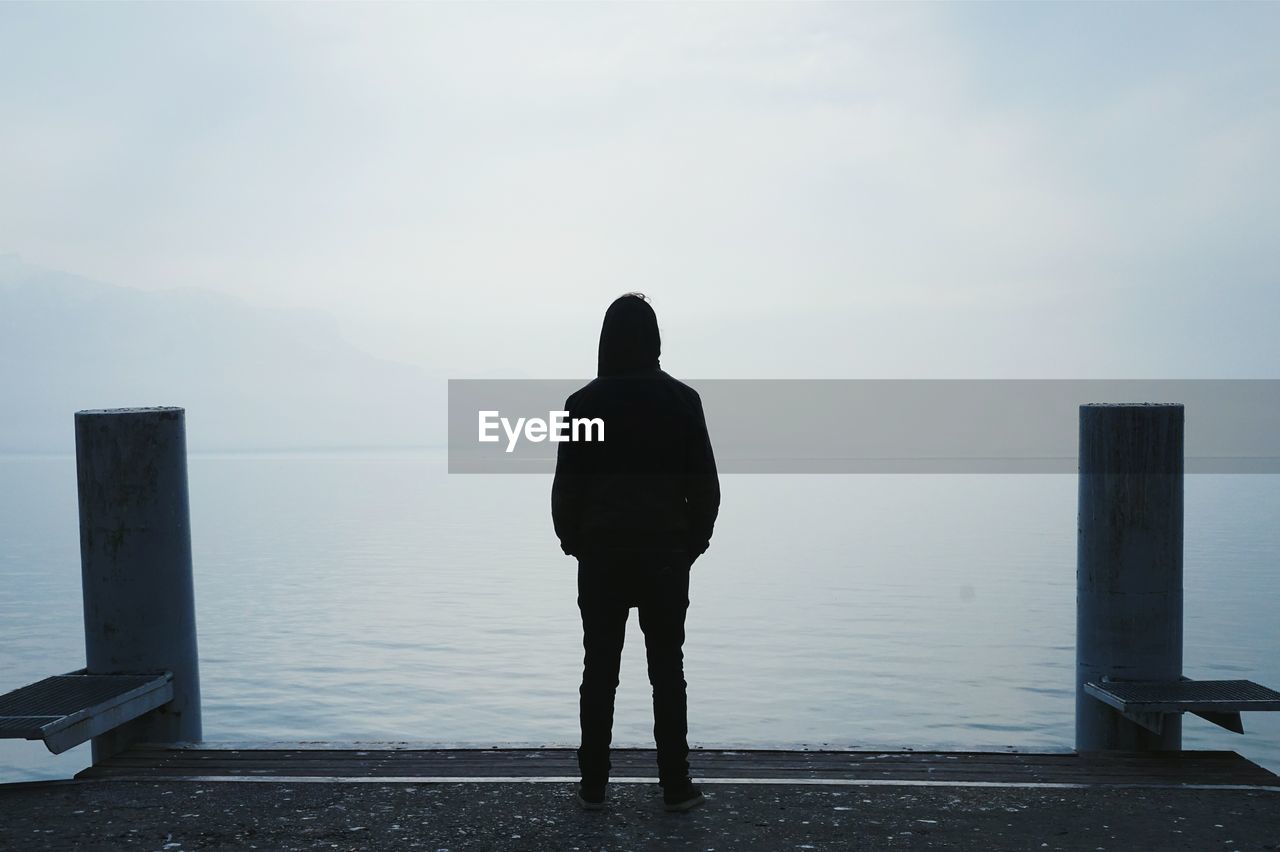 Rear view of man standing against sea
