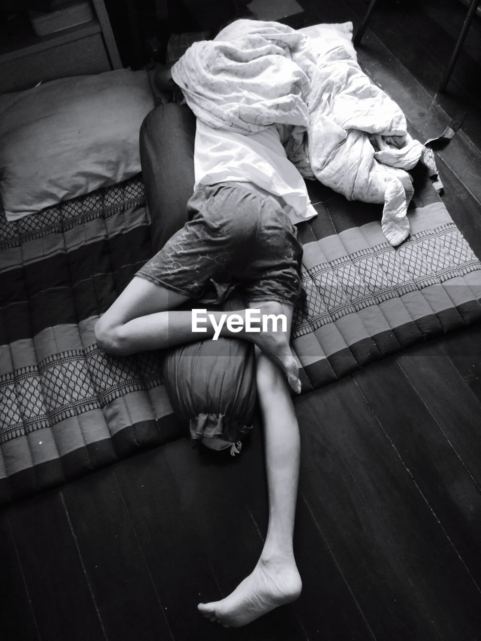 High angle view of man sleeping on mattress