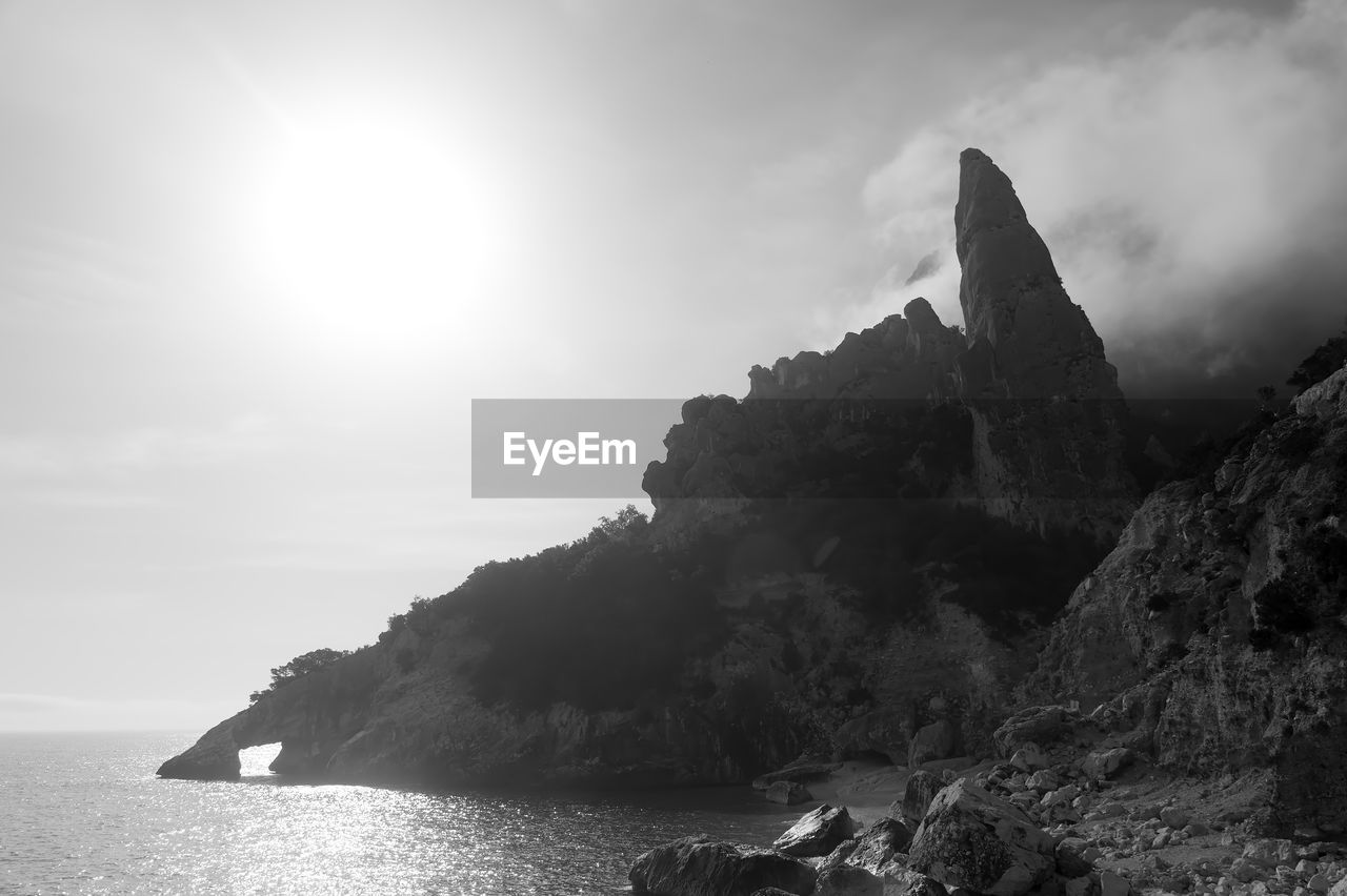 SCENIC VIEW OF SEA BY ROCK FORMATION AGAINST SKY