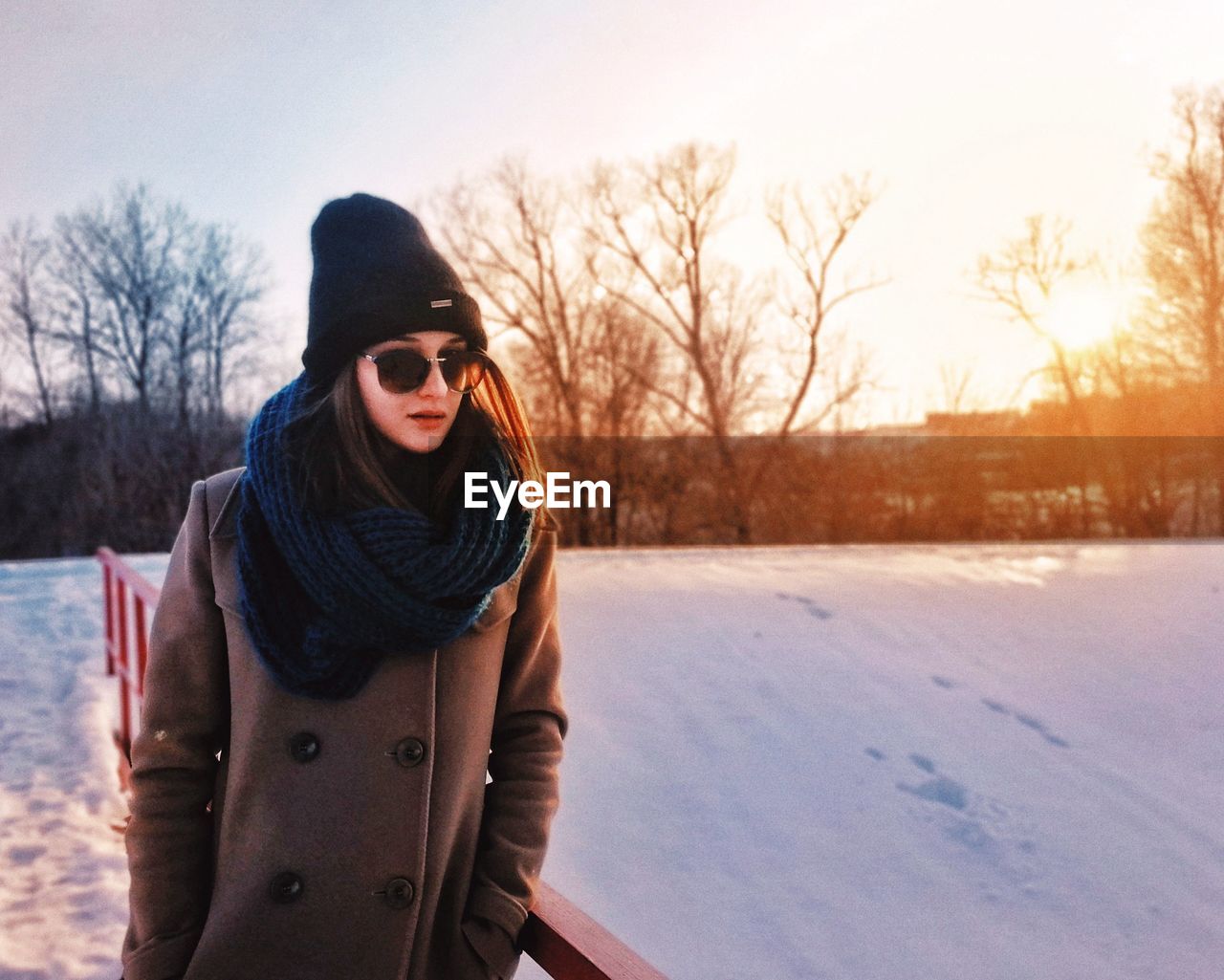 PORTRAIT OF BEAUTIFUL WOMAN STANDING IN SNOW AGAINST SKY